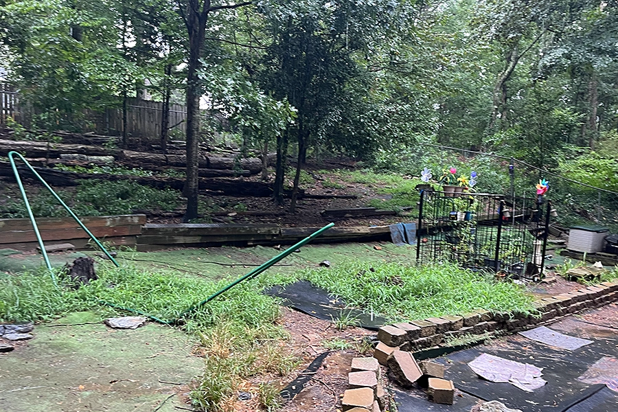 Failed timber retaining wall due to poor drainage and improper materials.
