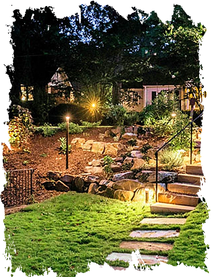 Finished landscape renovation featuring stone pathways and nighttime outdoor lighting in Druid Hills.